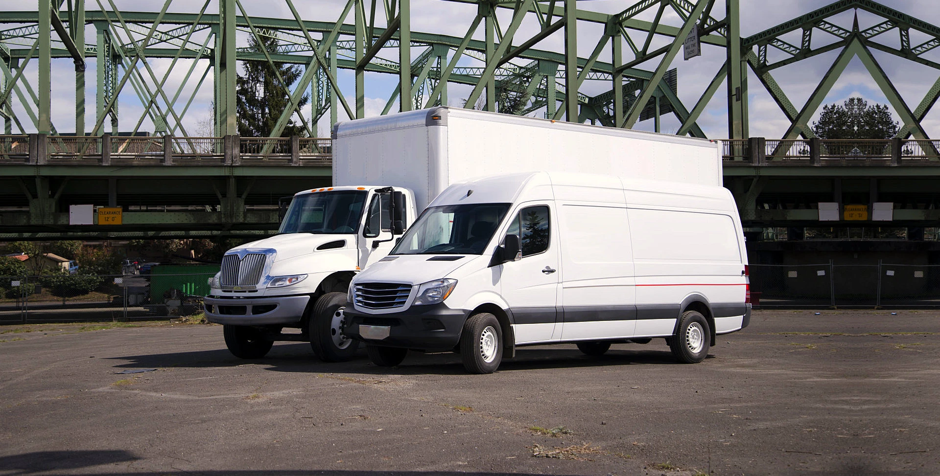 two white trucks parked on a parking area